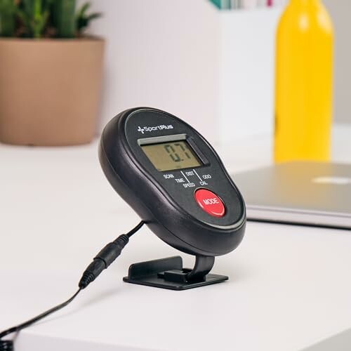 Digitalanzeige eines Fitnessgeräts auf einem Tisch.